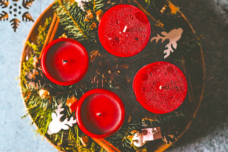 Four red candles shown from above on a wreath garland