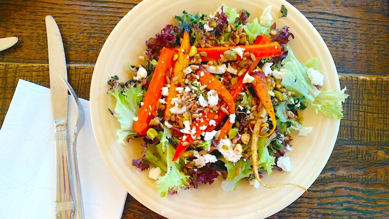 Marie's Farm Salad with Roasted Carrots and homemade citrus dressing on a plate with silverware