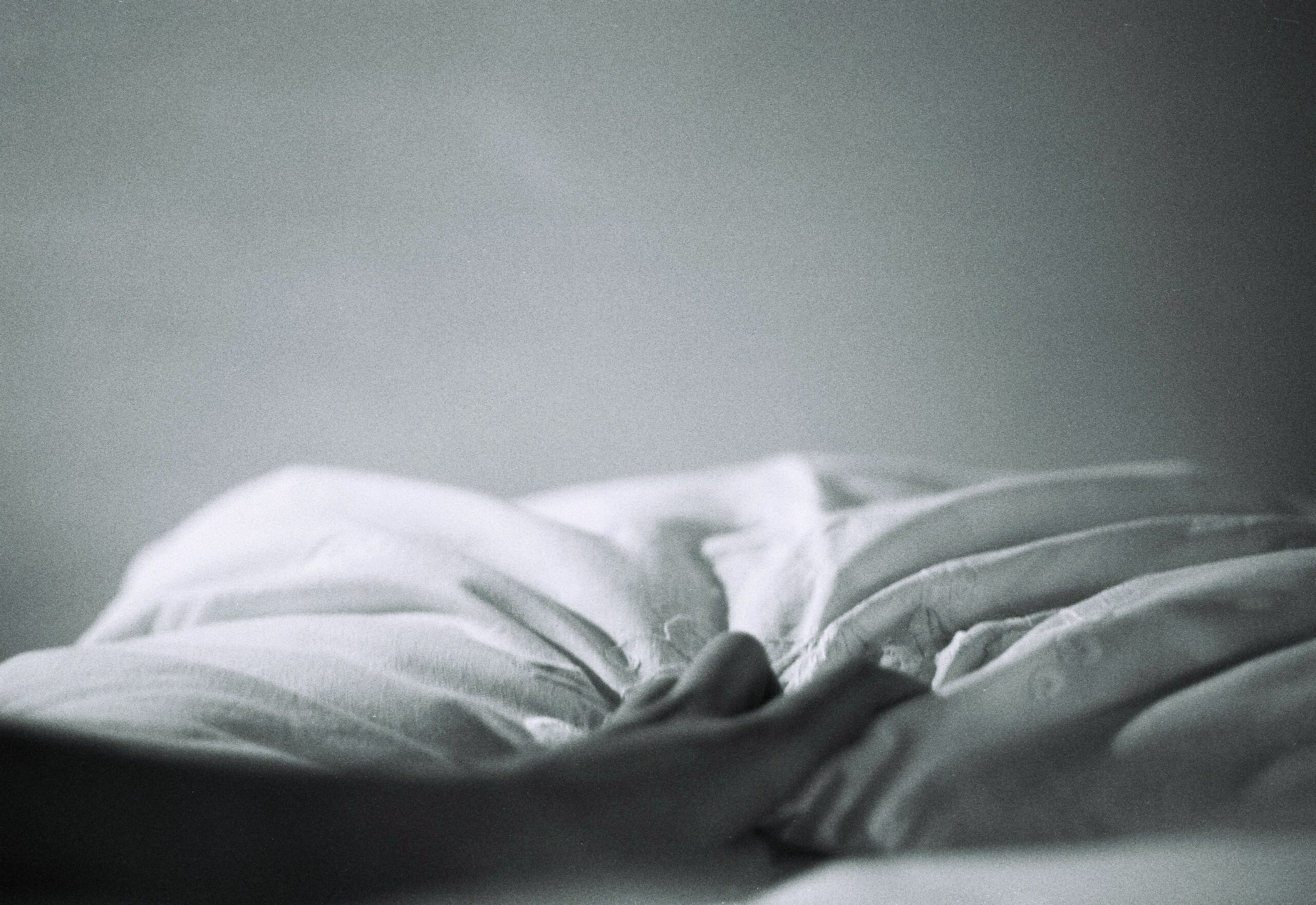 Ruffled bed sheets on an empty bed.