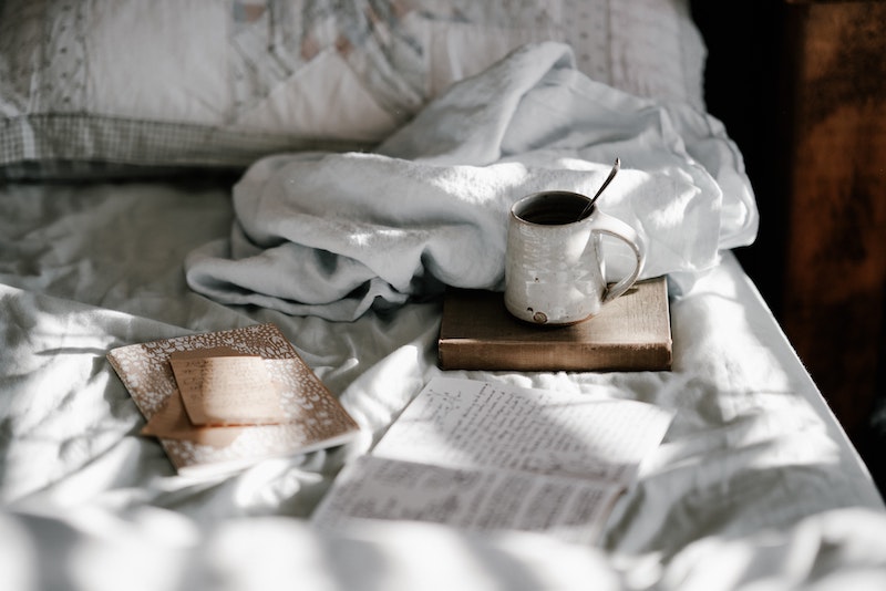 A cozy bed with books and tea