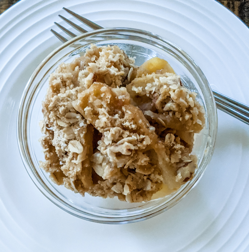 A serving of the finished easy fall recipe Apple Crisp in a bowl on a plate