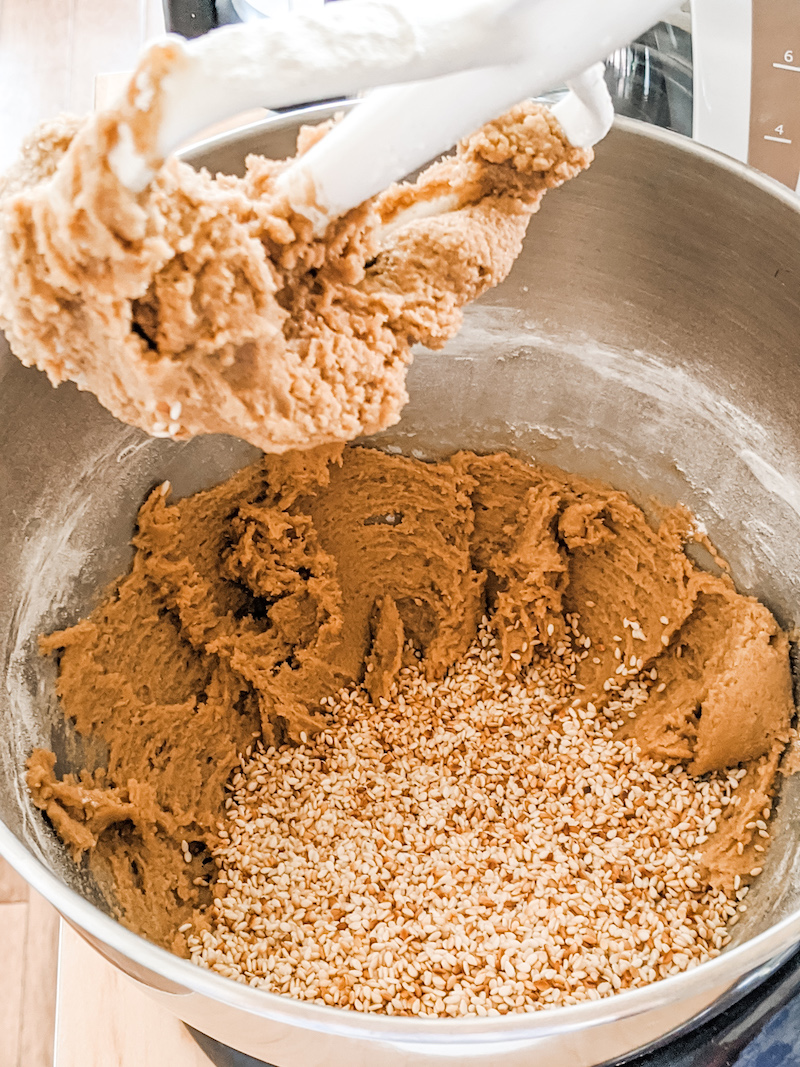 A mixer folding the sesame seeds into the benne wafers batter