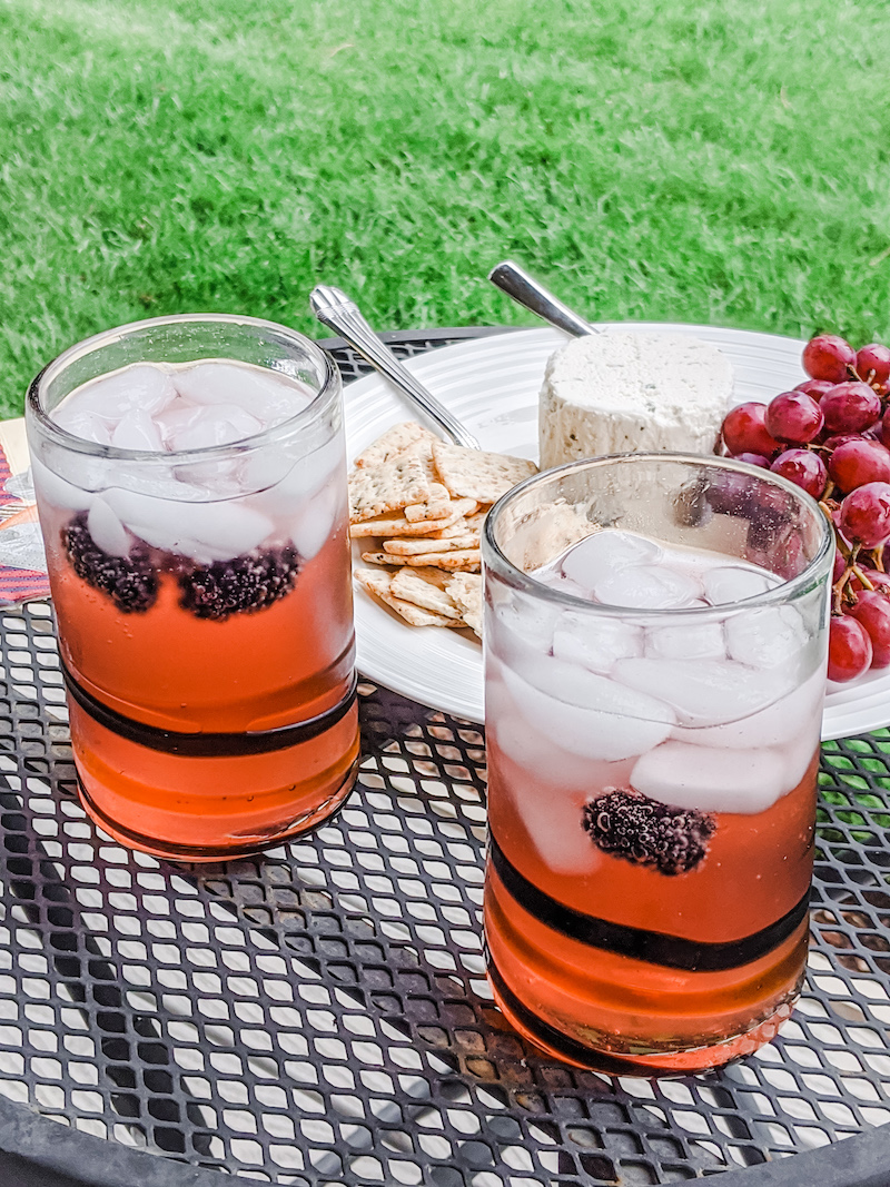 Cocktailes made using fruit shrub, alongside a cheese plate