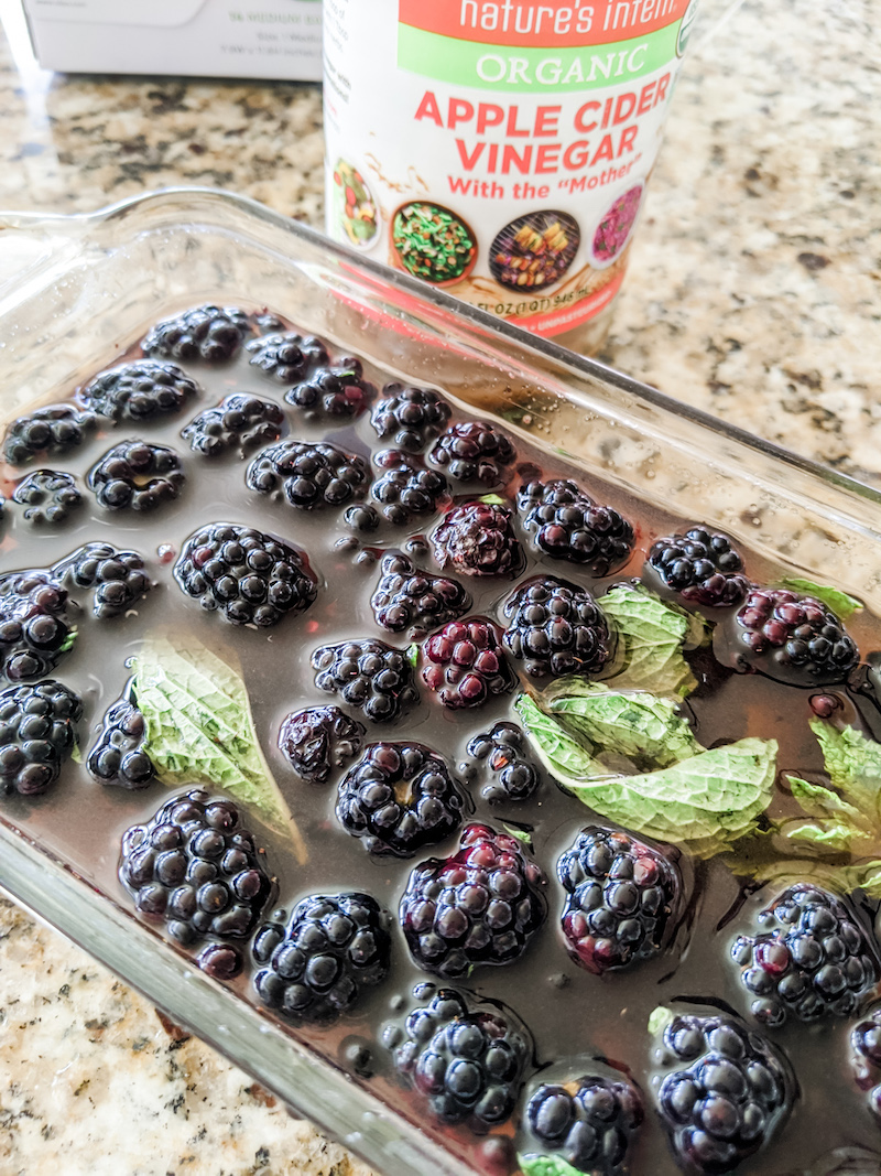 Blackberries soaking in apple cider vinegar with herbs