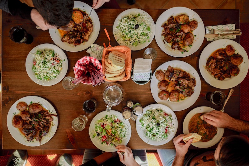 A fall activity of a feast - a table with several autumn dishes and folks eating