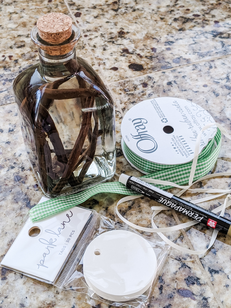 The non-decorated bottle surrounded by ribbon, white marker, and label