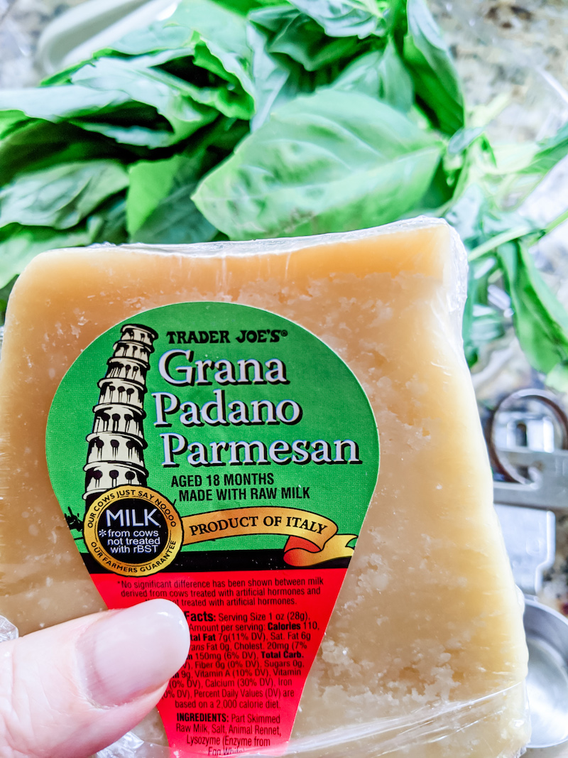 Grana Padano Parmesan from Trader Joe’s held above a bed of spinach