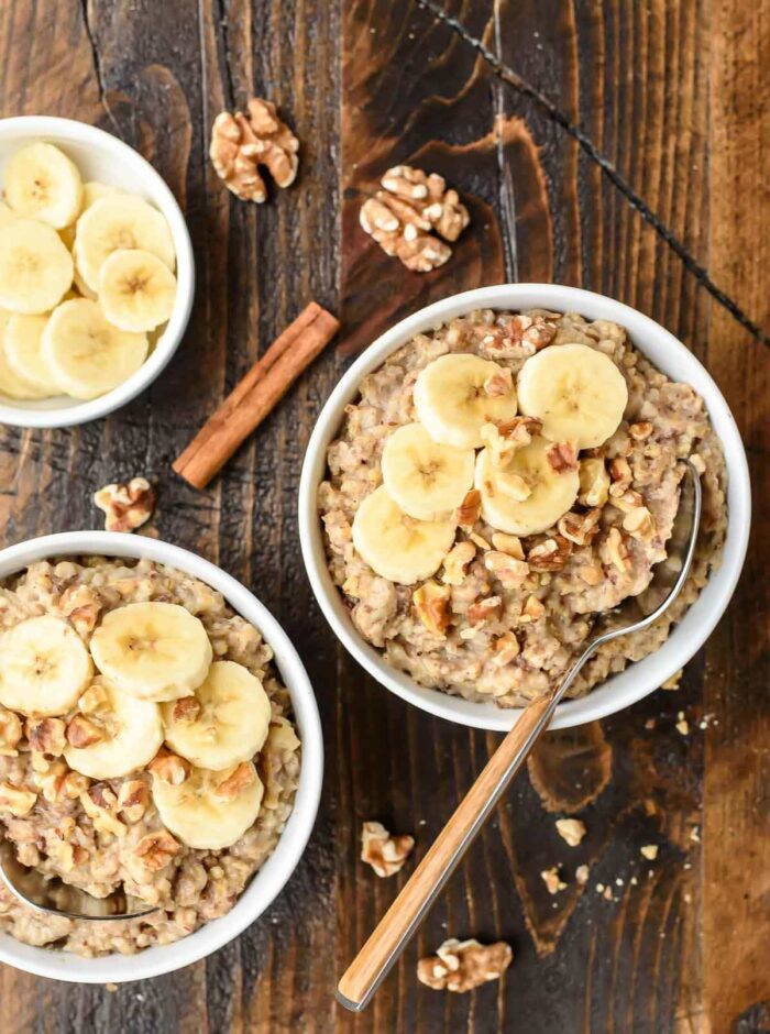 Several bowls of overnight oats with cinnamon sticks and slices of banana 
