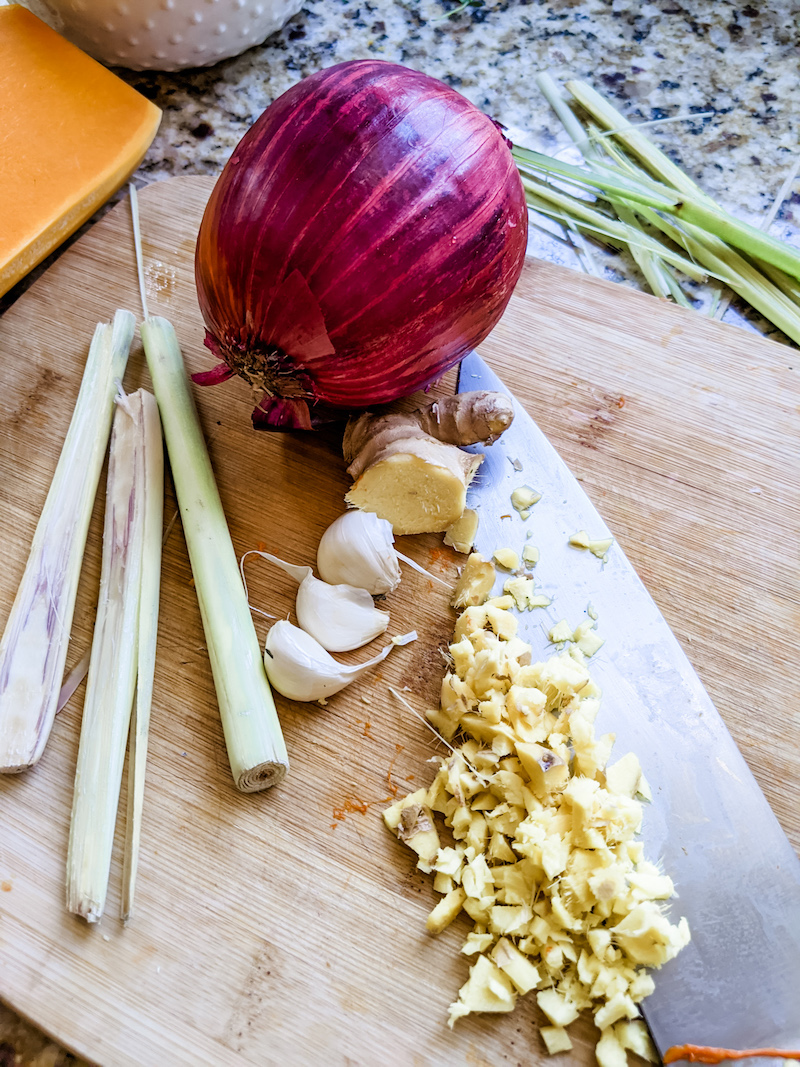 The ingredients for the slow cooker Thai Butternut Squash Soup, lemongrass, garlic, and an onion