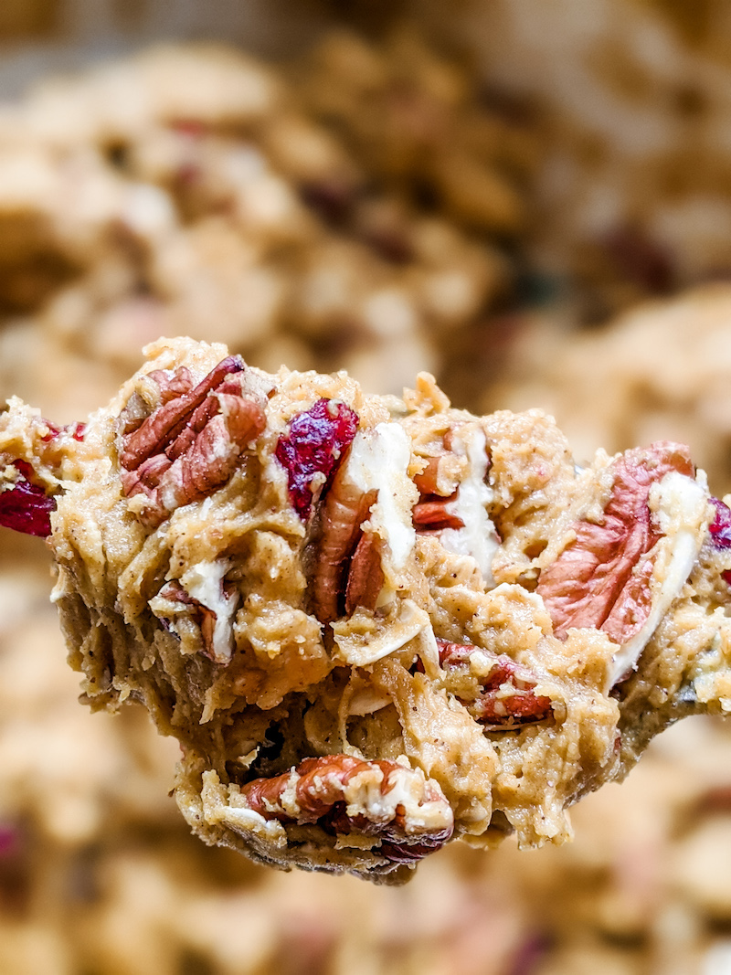 The pecans in the chewy pumpkin harvest cookies dough, held up on a spoon