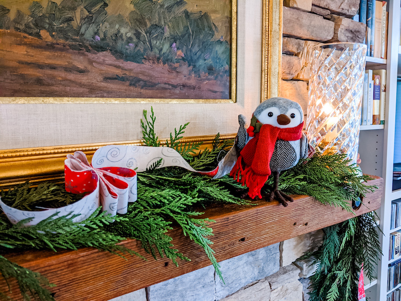 The DIY Christmas Garland on a mantle piece along with a bird knick knack and evergreen garland