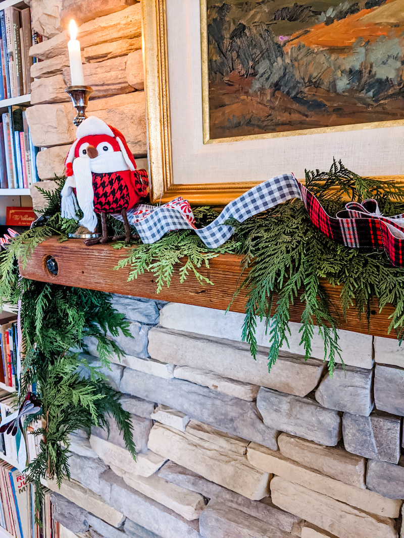 The DIY Christmas Garland on a mantle piece along with a bird knick knack and evergreen garland