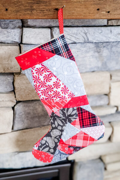 The Easy Patchwork DIY Christmas Stockings hanging on a stone fireplace
