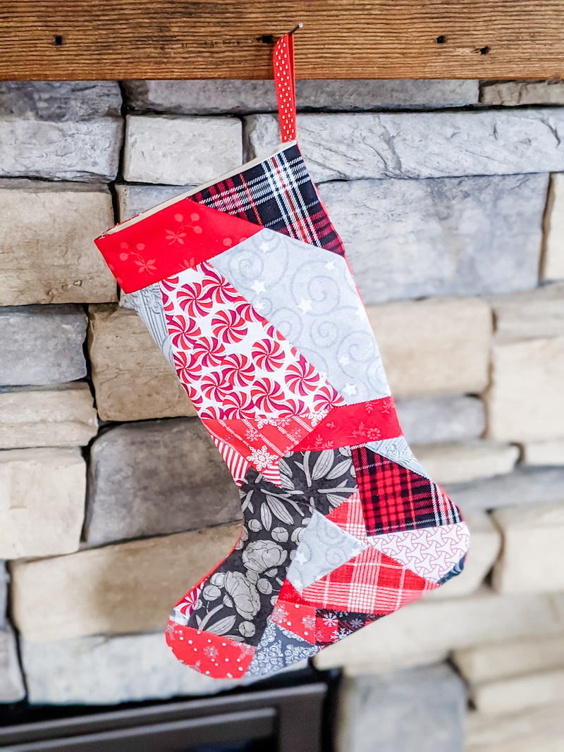 The Easy Patchwork DIY Christmas Stockings hanging on a stone fireplace