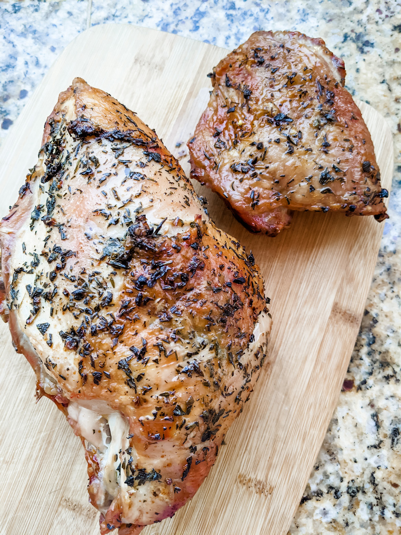 The finished oven roasted turkey breast resting on a wooden cutting board for a small scale Thanksgiving