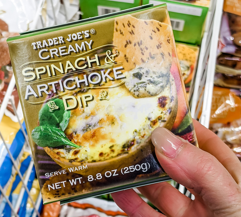 A hand holding the spinach artichoke dip box - a Trader Joe's Winter Favorite of Marie's