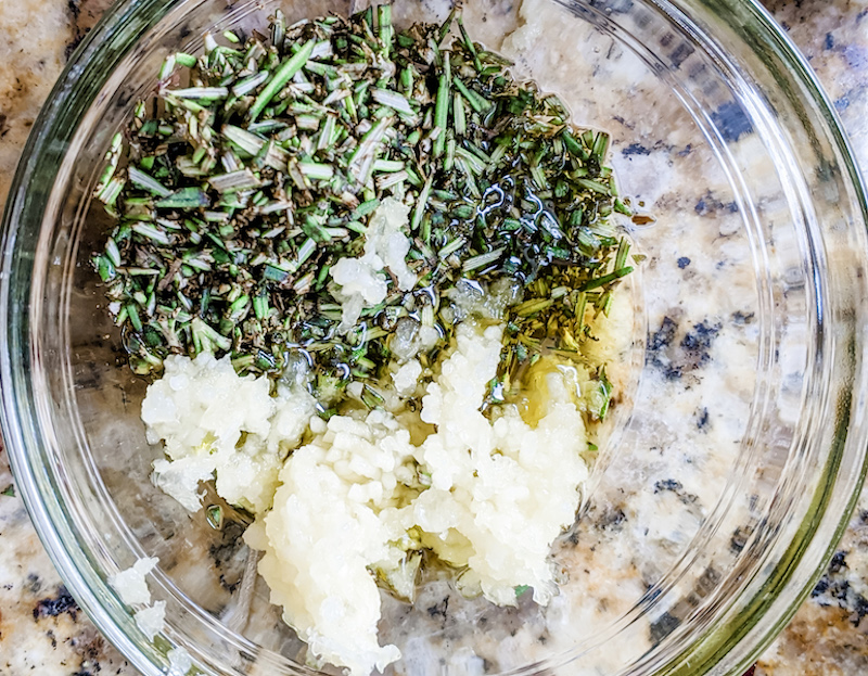 The unmixed ingredients for the marinade in a clear glass bowl.