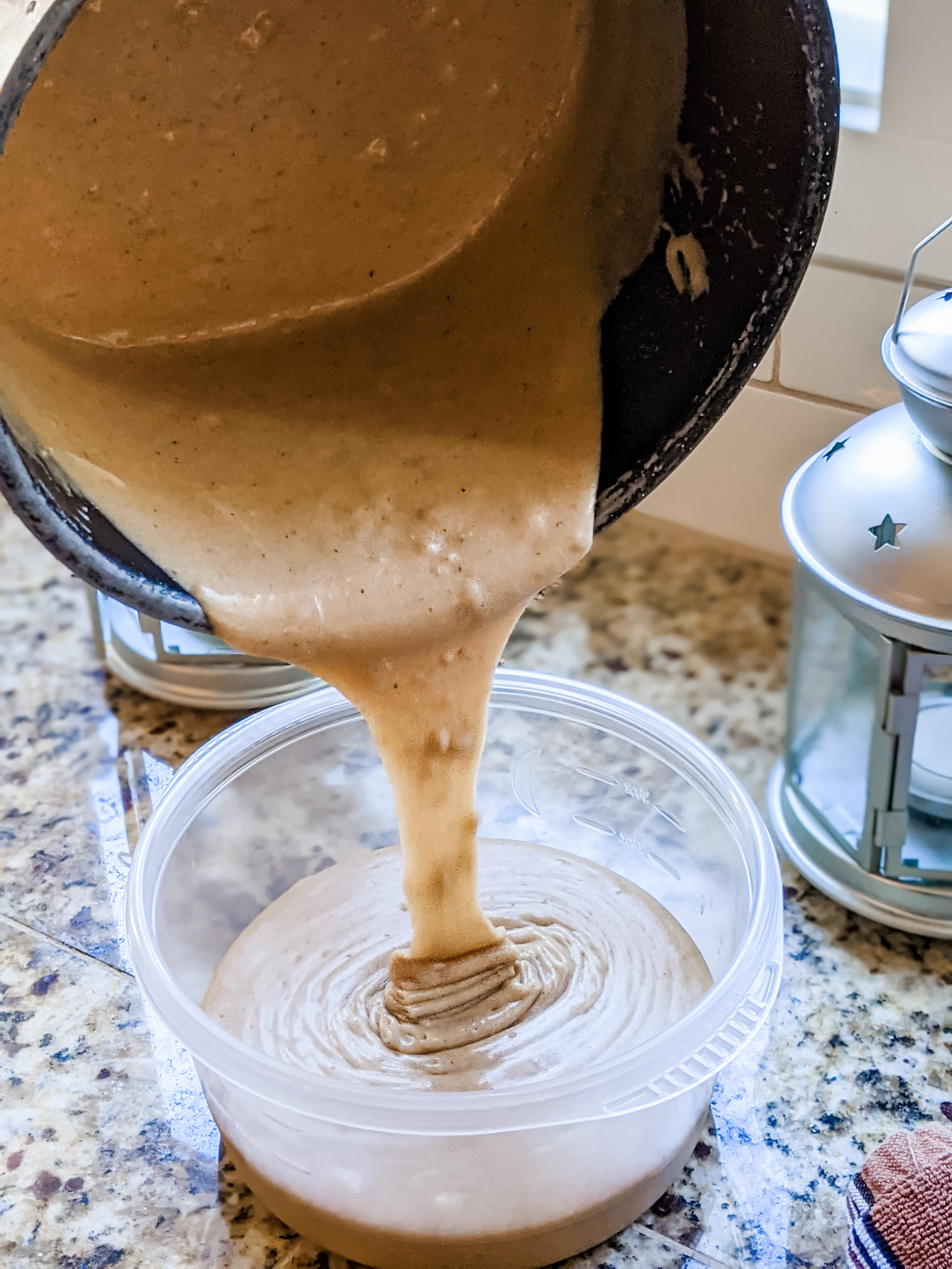 The mixture for the drink being poured into the mug/