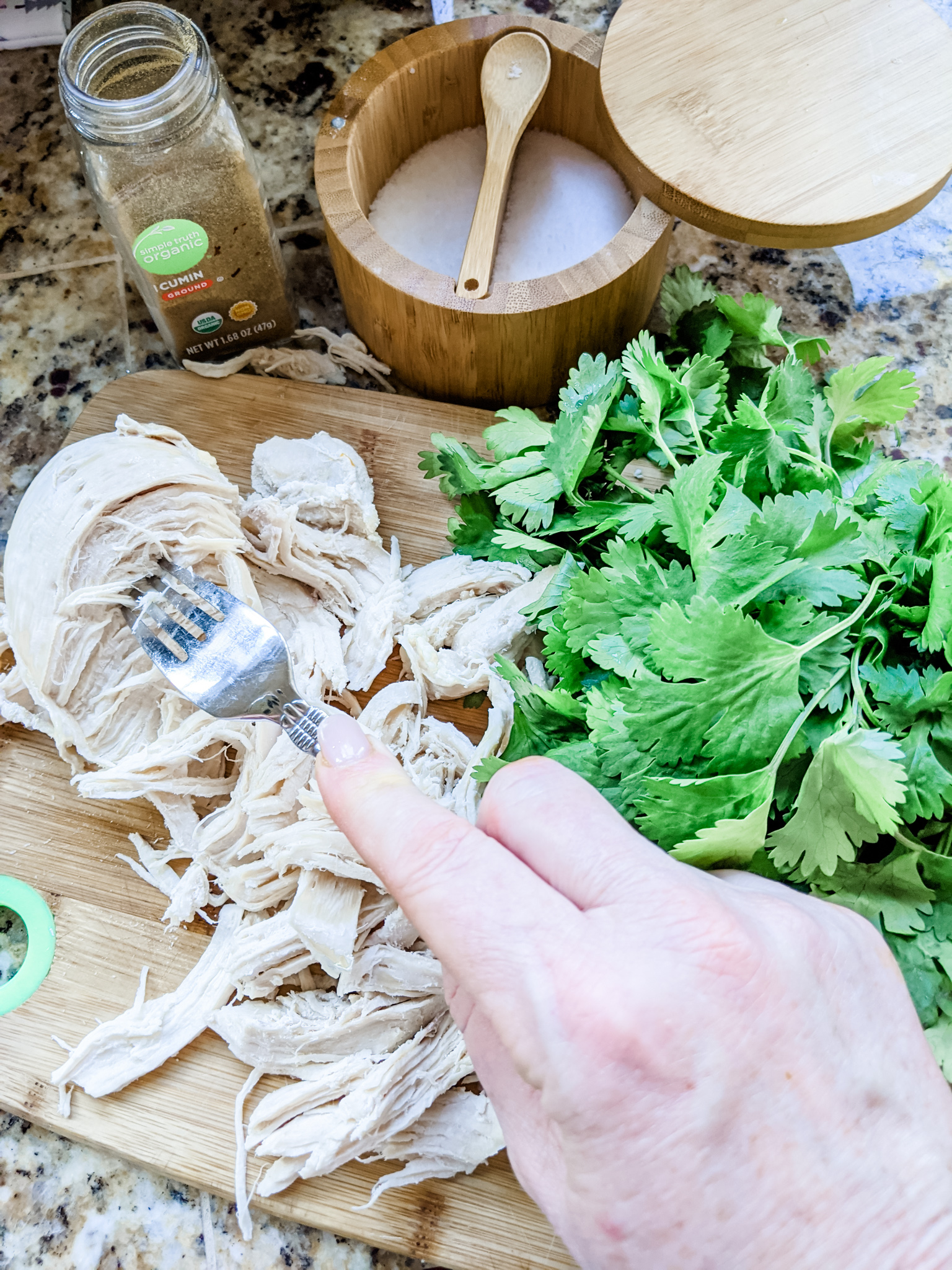 The ingredients - shredded chicken, diced pepper, and seasoning on a cutting board