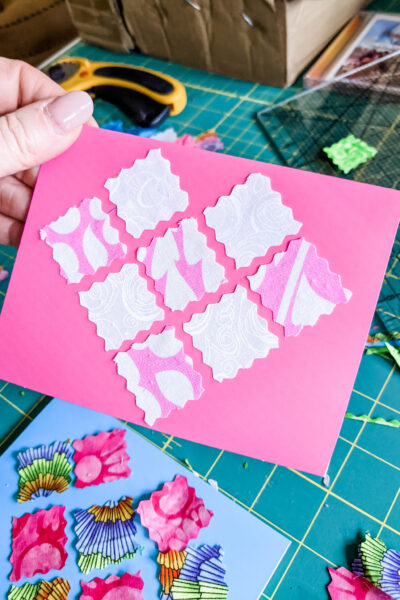 Marie holding one of the finished Fabric DIY Valentines above her crafting supplies.