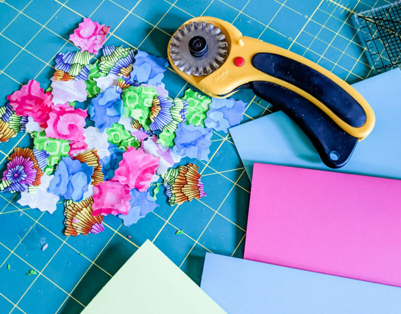 The materials needed - a rotary cutter, rubber mat, fabric, and envelopes