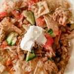 The finished and plated Healthier Chicken Nachos topped with guac and sour cream