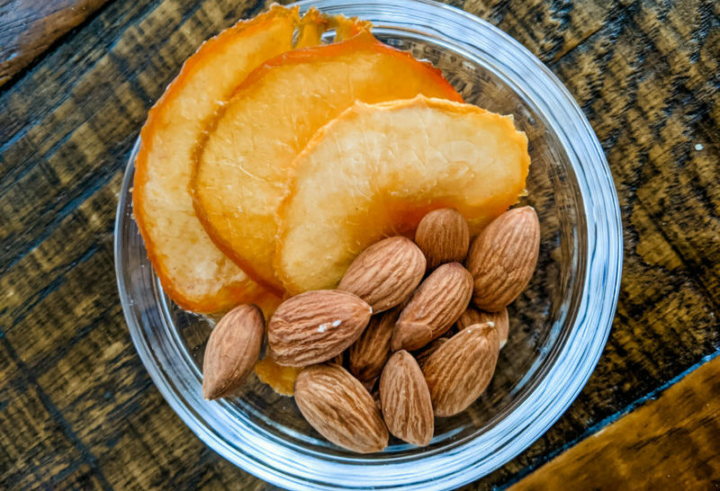 Dried peaches and almonds nestled into a clear container - a perfect and easy healthy snack from home