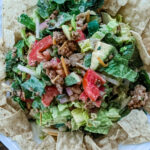 The Chicken Taco Salad plated and mixed, surrounded by tortilla chips for dipping.