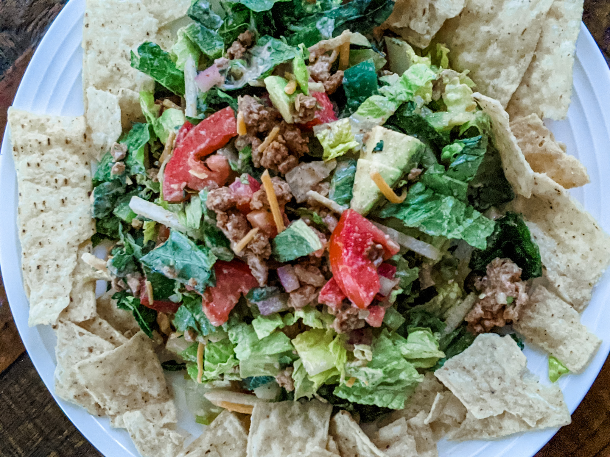 The Chicken Taco Salad plated and mixed, surrounded by tortilla chips for dipping.