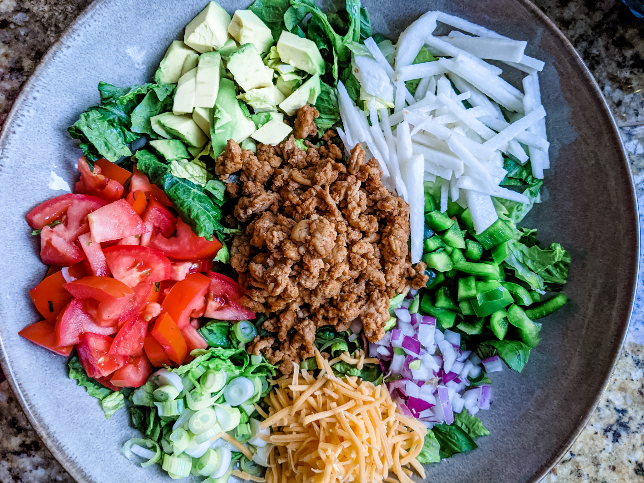 The Chicken Taco Salad, not mixed, in a stone bowl