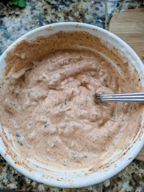 The finished healthy salad dressing in a white bowl with a spoon