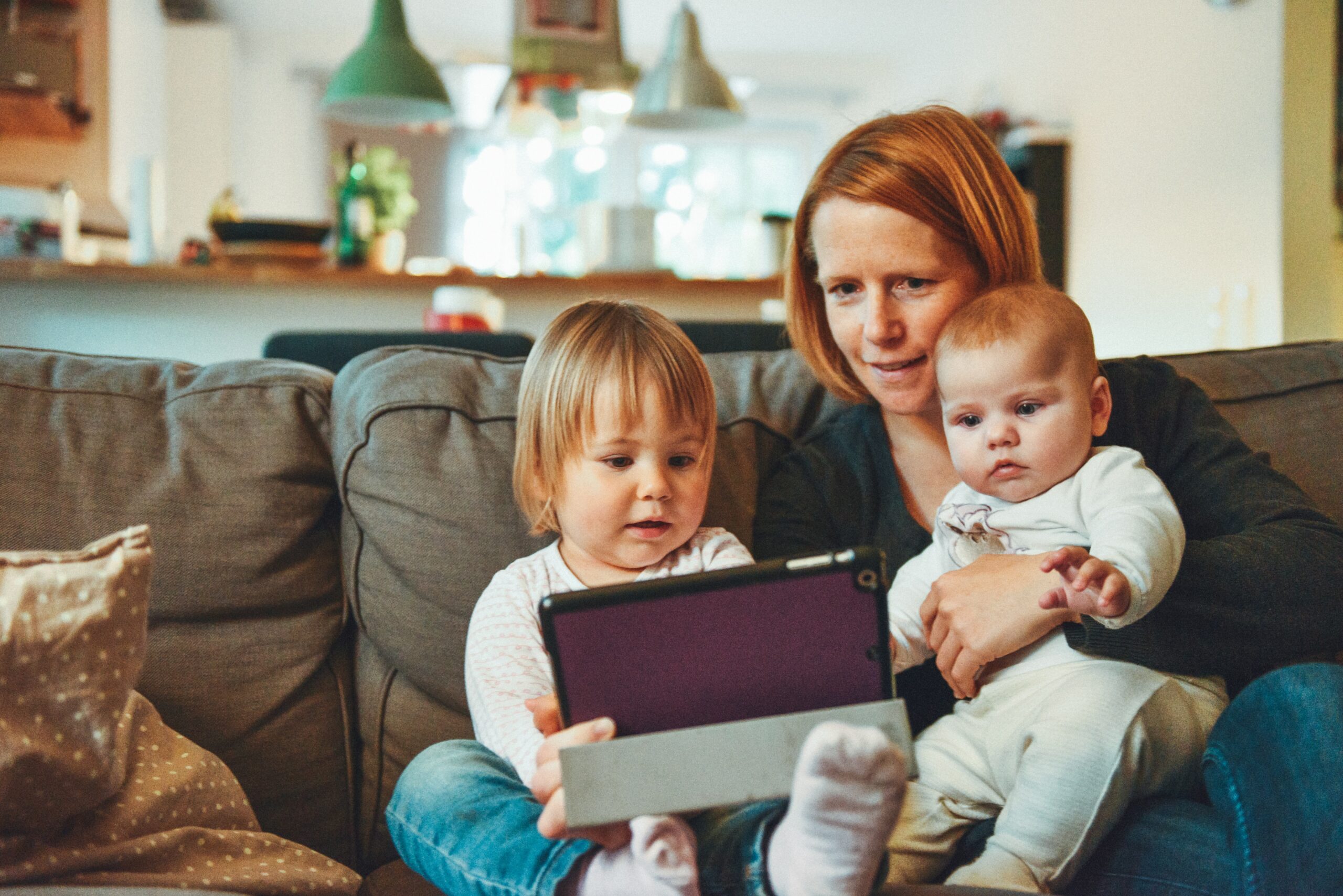 A woman and her small children use an ipad to facetime.