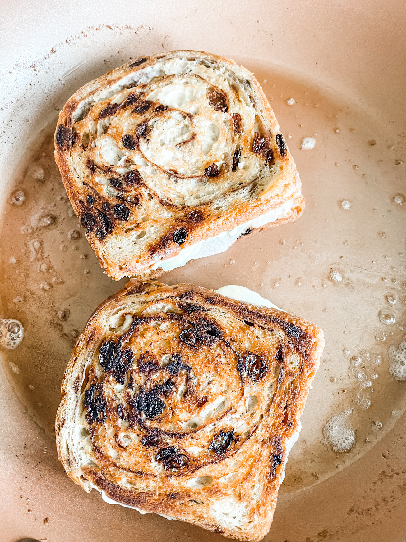 The Grilled Apple and Brie Cheese Sandwiches being toasted in a buttered pan