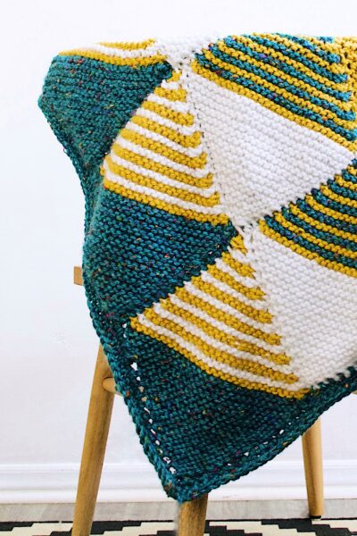 The finished Knitted Baby Blanket draped over a chair