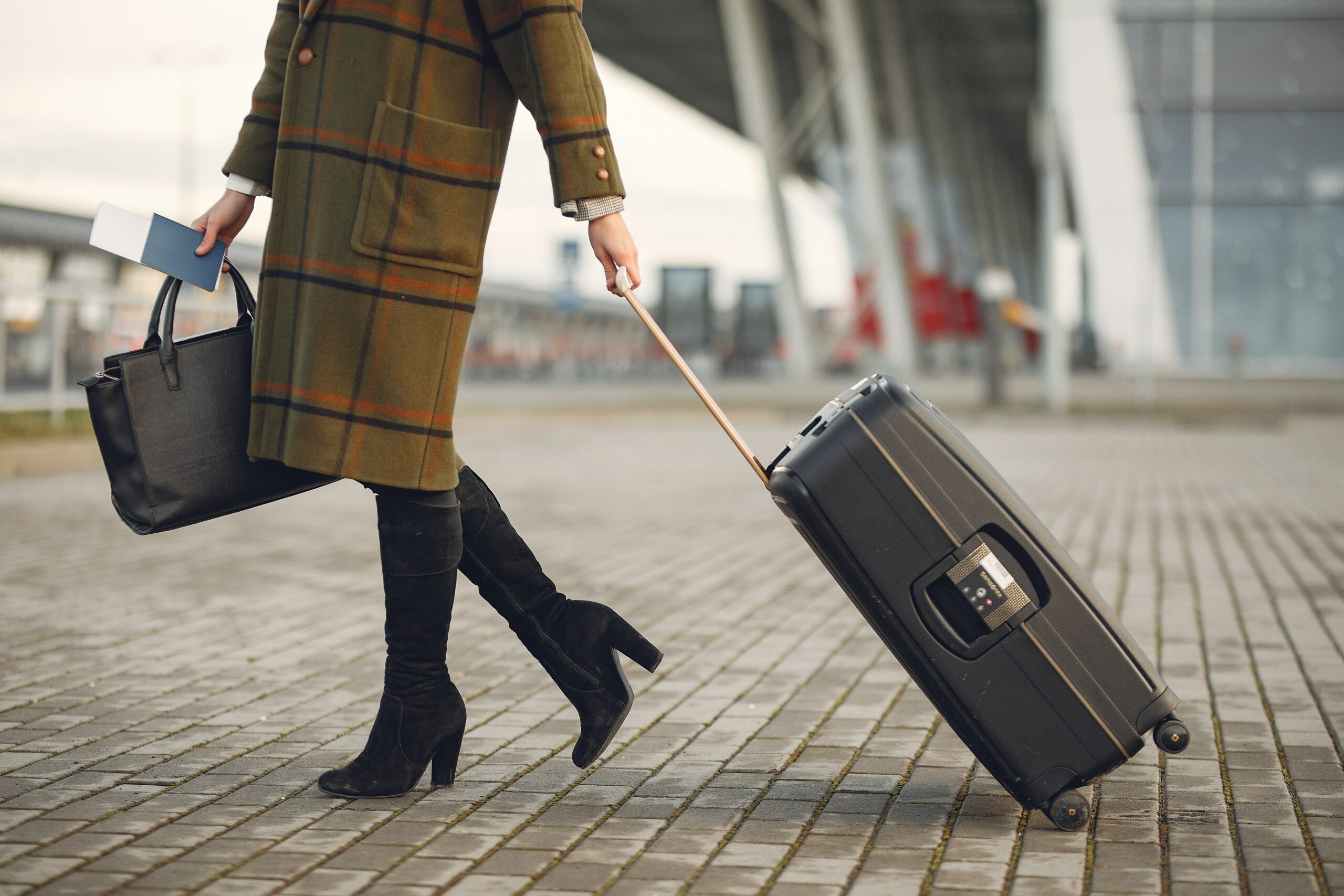 A woman with a handbag and a rolling carry on