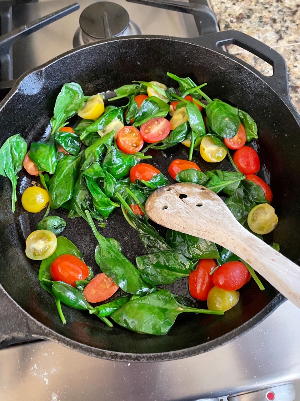 The spinach and cherry tomatoes for the Easy Weekend Breakfast Skillet in the skillet