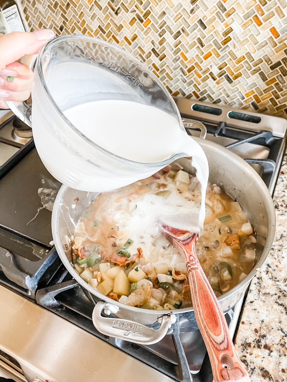 The heavy cream mixture being poured into the stockpot for the Quick and Creamy Seafood Chowder