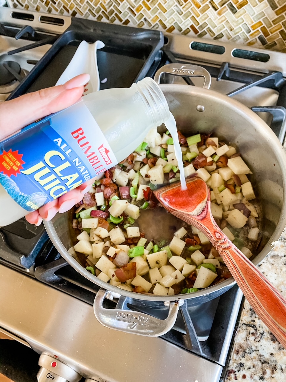 Marie pouring clam juice into the pot of potatoes, celery, and bacon