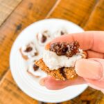 A hand holding one of the Whipped Feta Appetizers with Fig