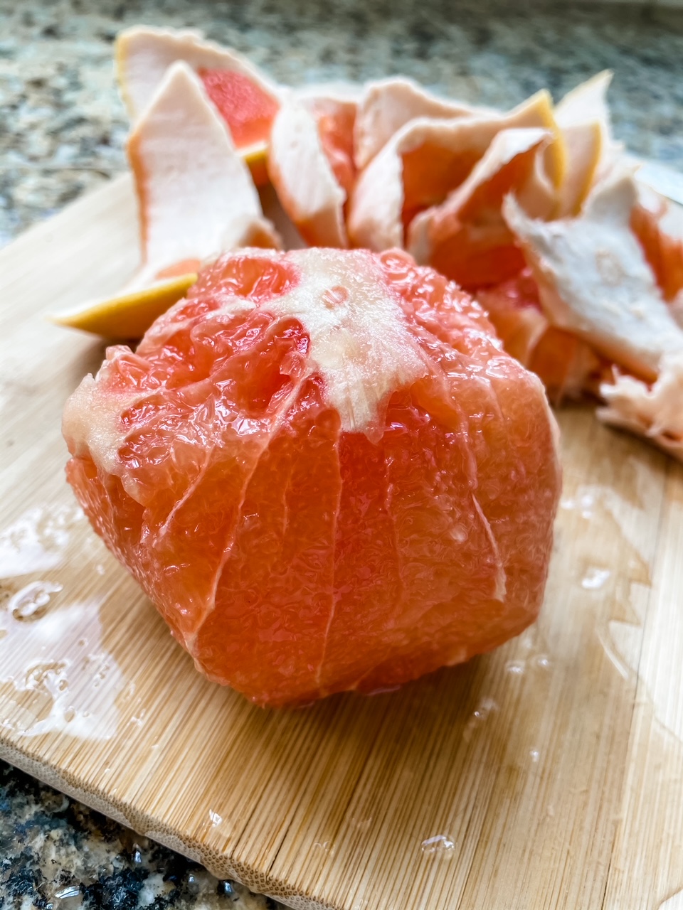 A partially completed grapefruit supreme that hasn't been separated from the membrane yet