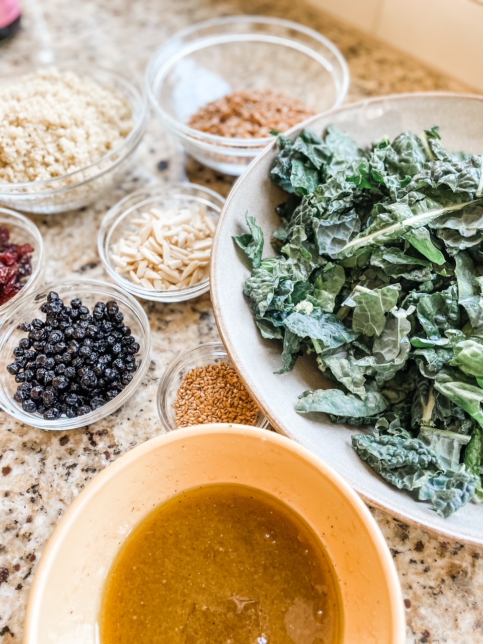 The ingredients for the Kale Superfood Salad Recipe laid out in individual bowls.