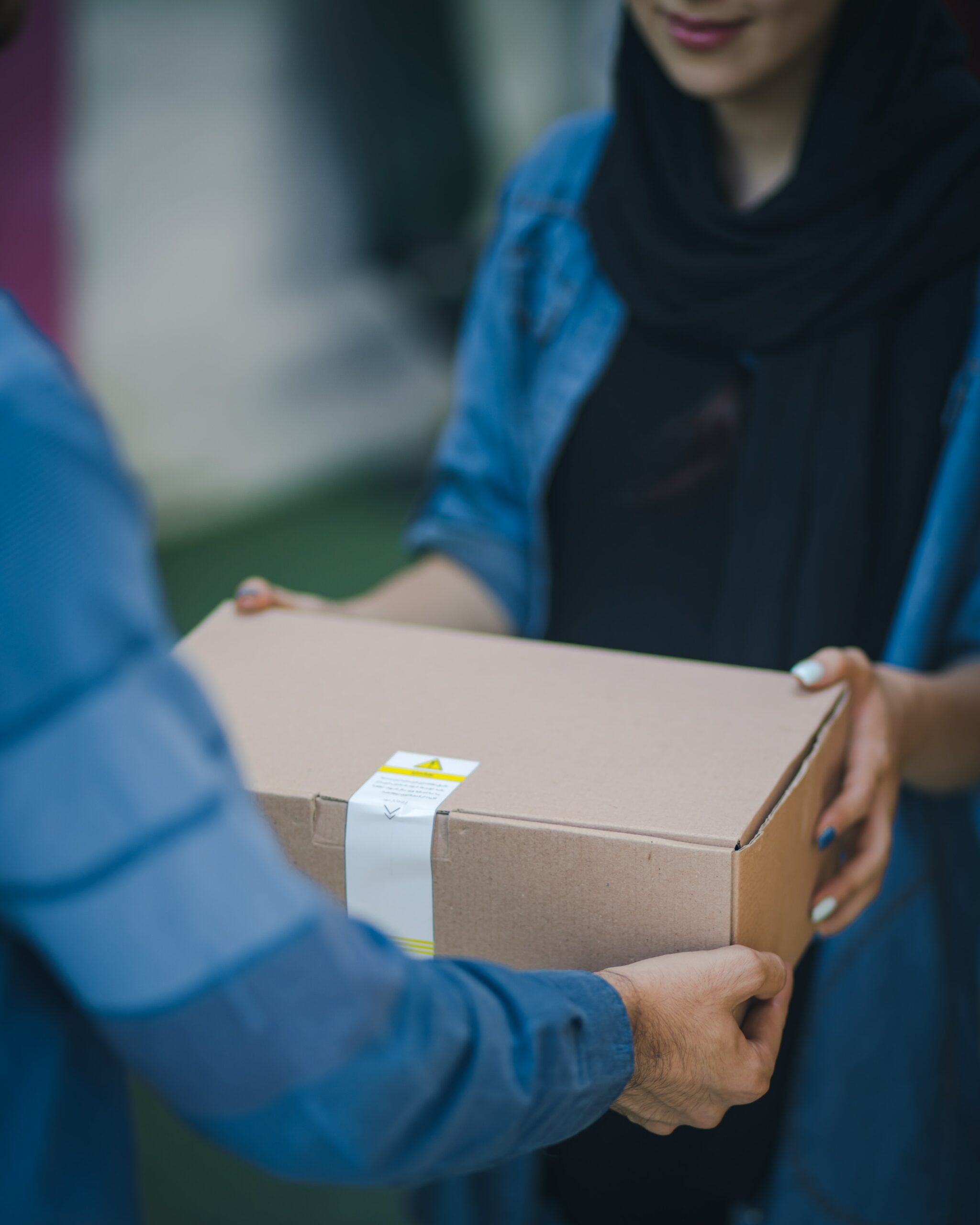 A woman passing a box to another person.