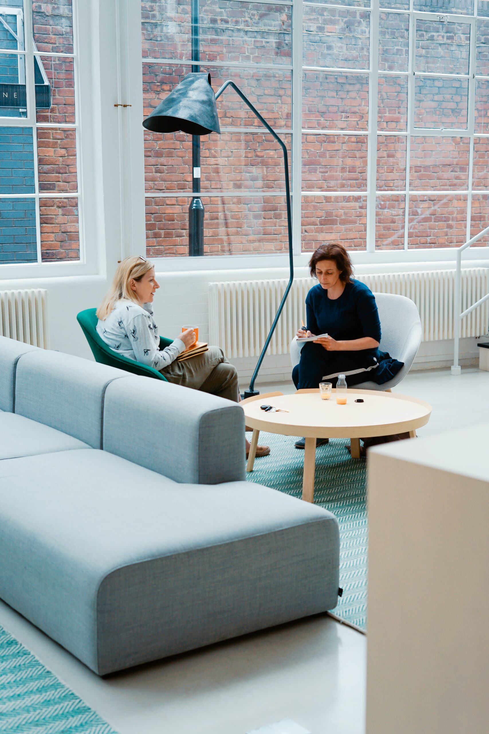 Two women in an office space having a discussion.