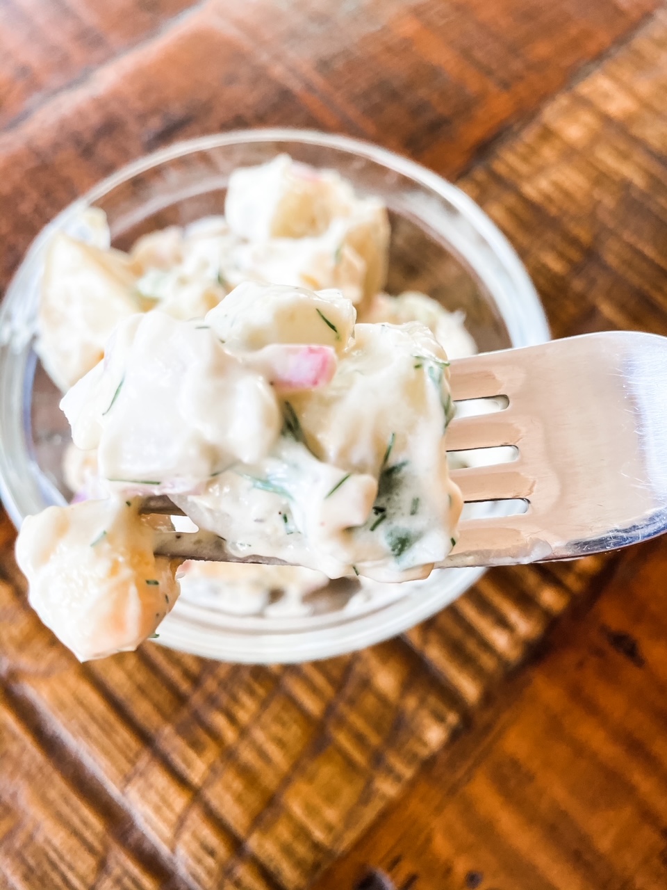 A bowl of the Potato Salad with Dill with a forking digging into it.