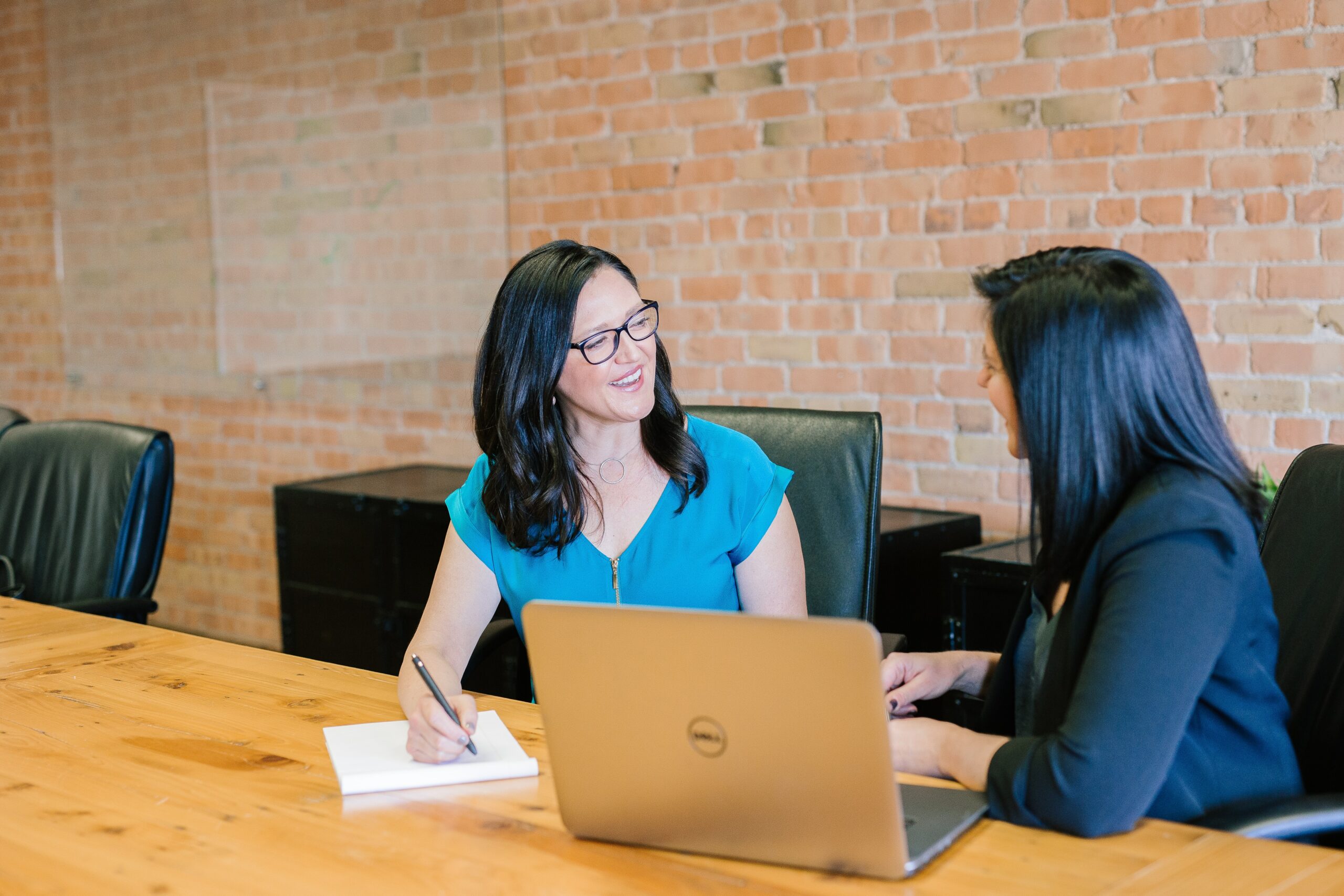 A woman speaking to a realtor at a table one of the homebuying tips and tricks