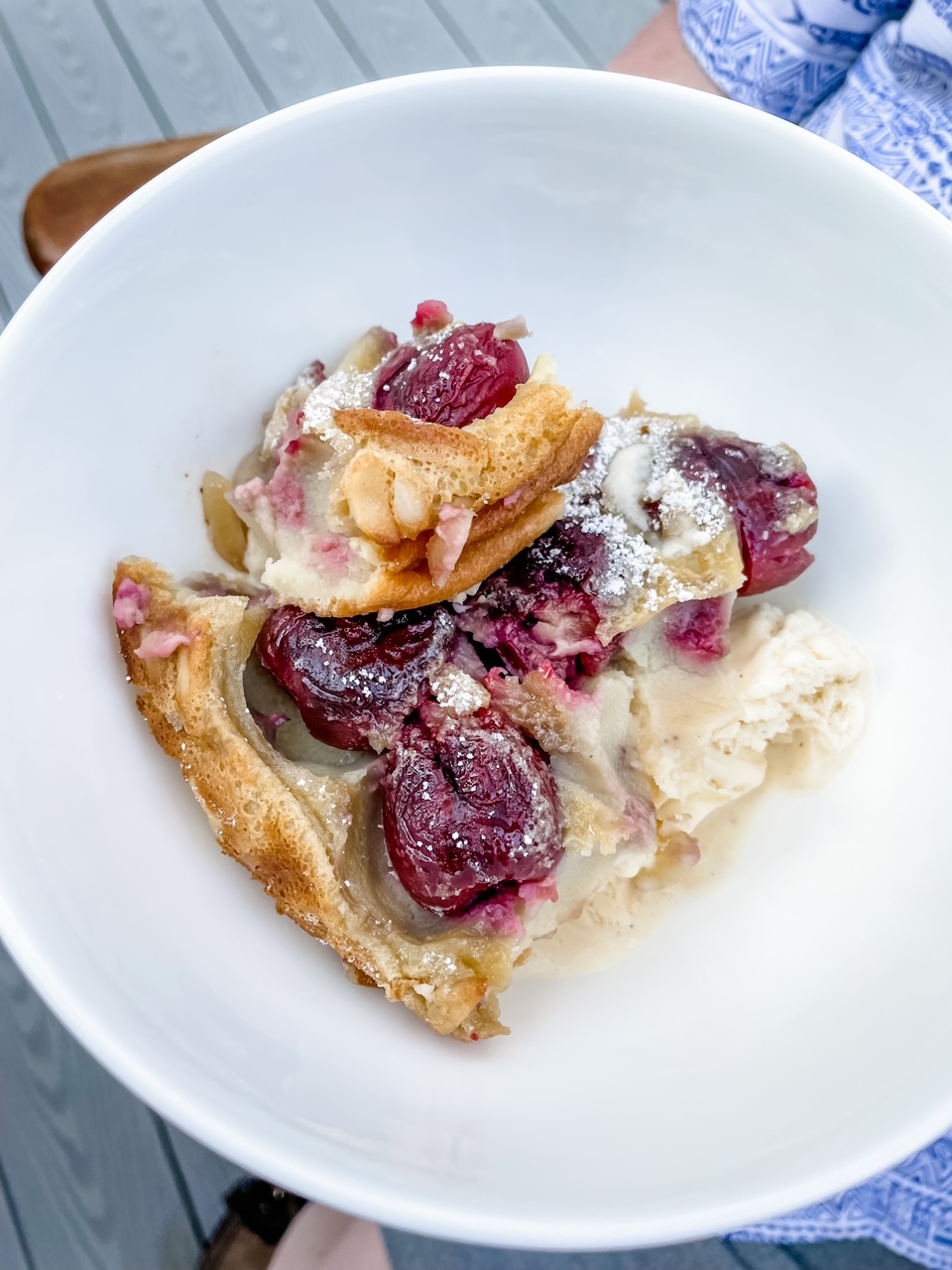 A slice of the Fresh Cherry Clafoutis in a white bowl