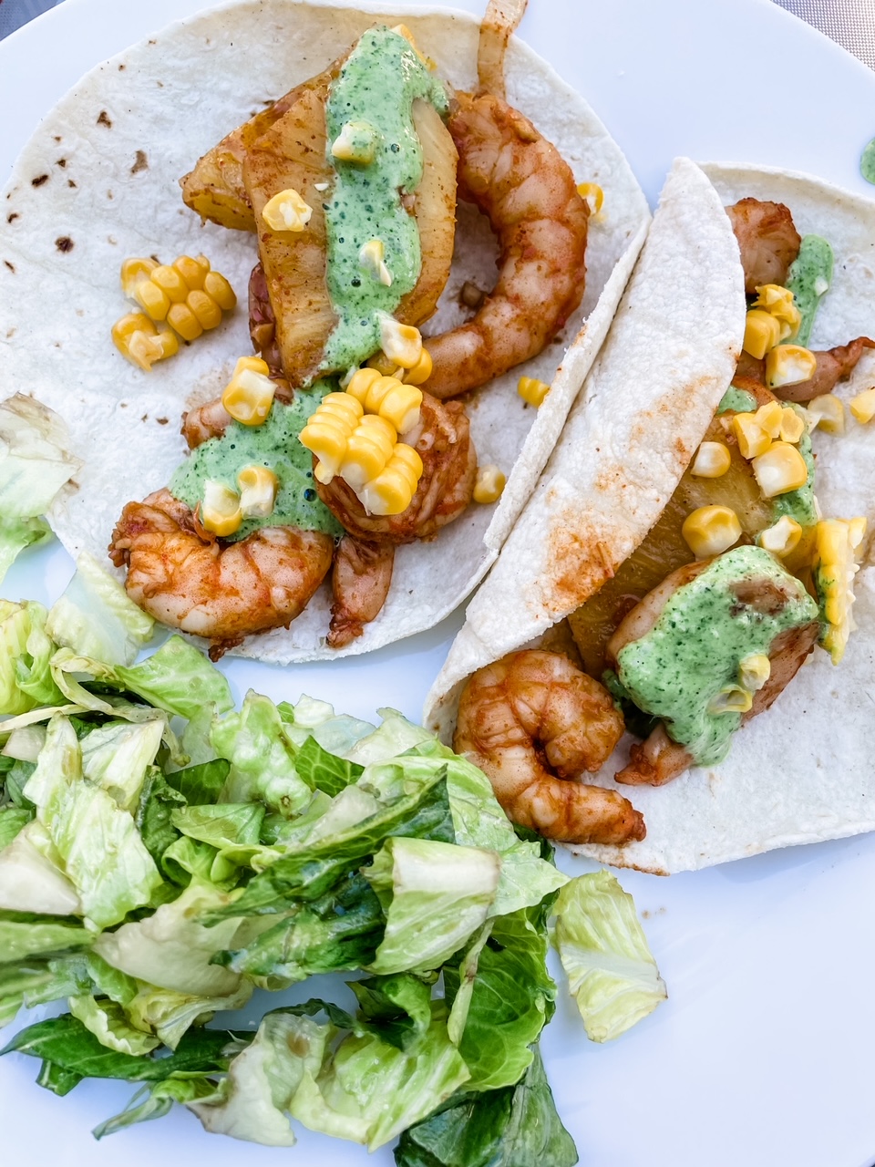 Two of the finished Sheet Pan Shrimp Street Tacos on a plate