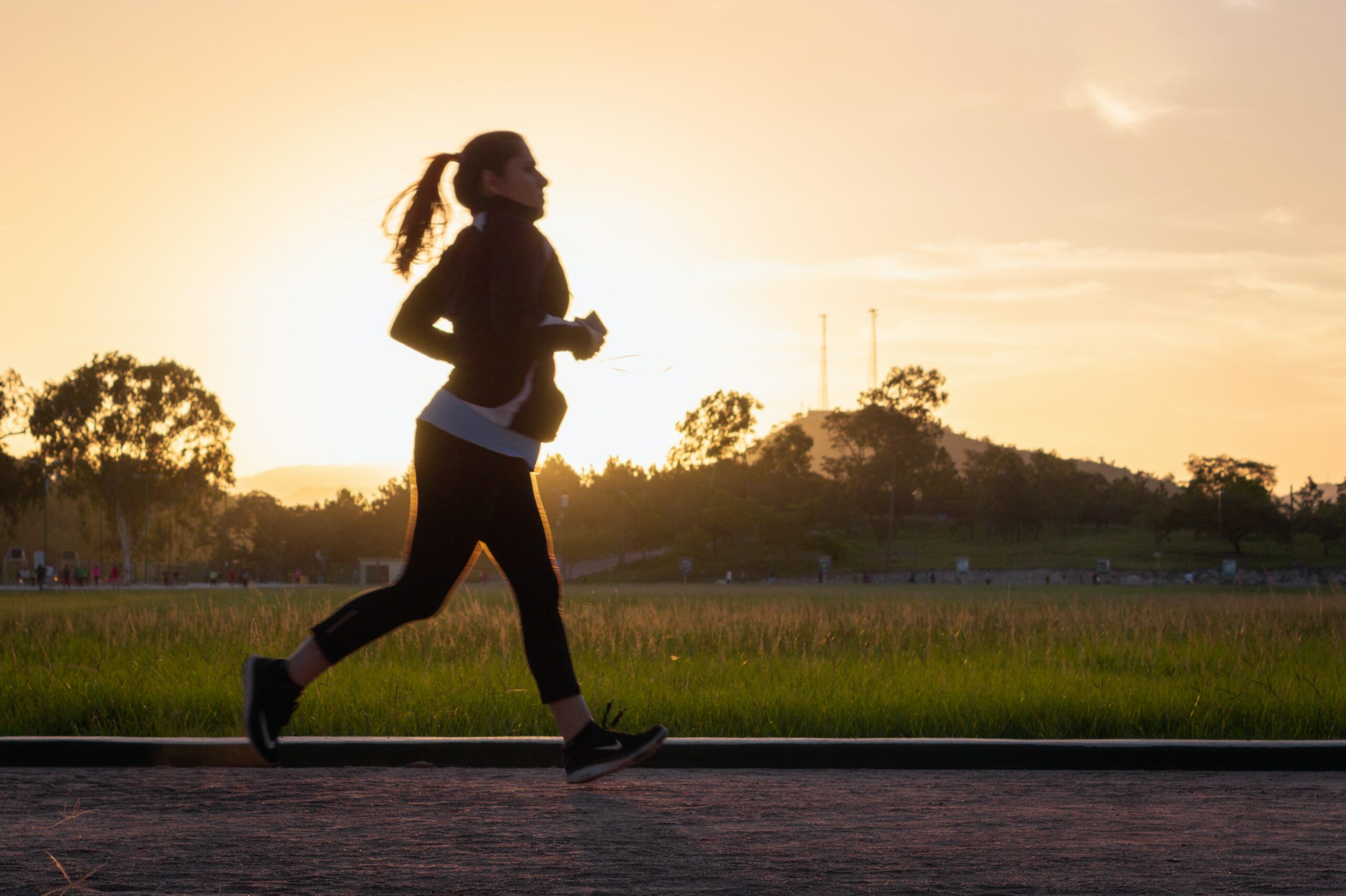 A woman jogging along a sunset