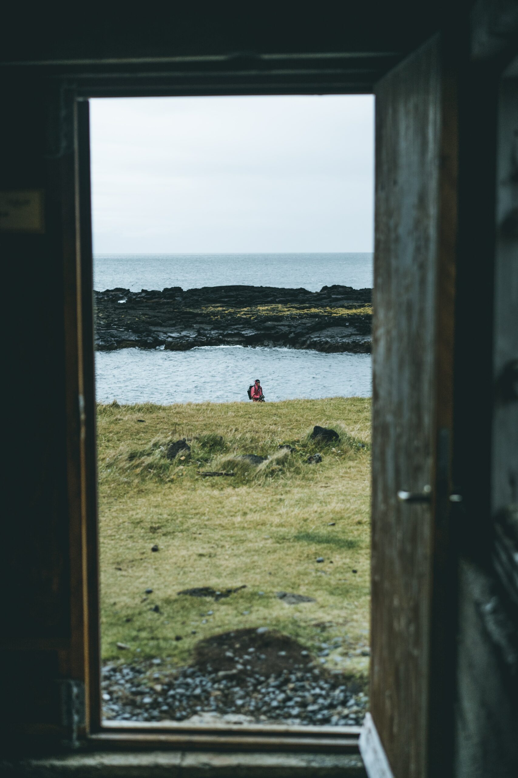 A door opening up to a green landscape with a lake - a symbol of a re-beginning