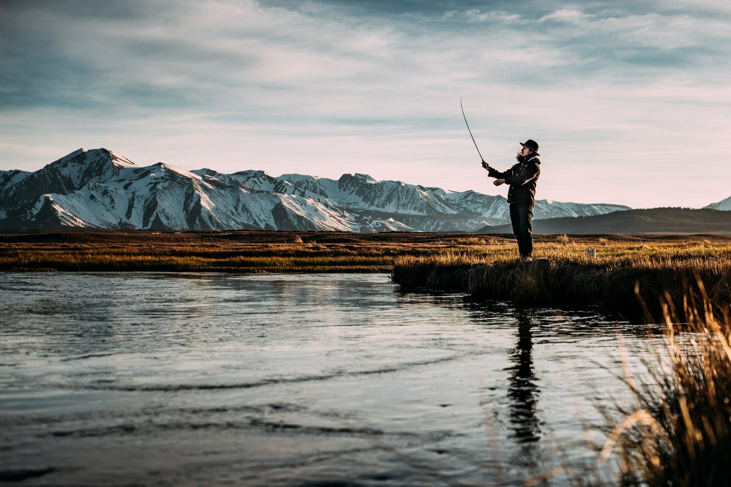 A man flyfishing with a mountain in the background - one of the things to do in Bend, Oregon